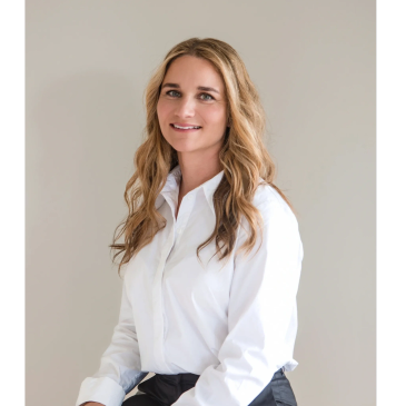 Professional woman with long hair in white shirt smiling.