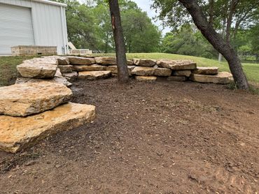 A stone seating area built around two trees near a building.