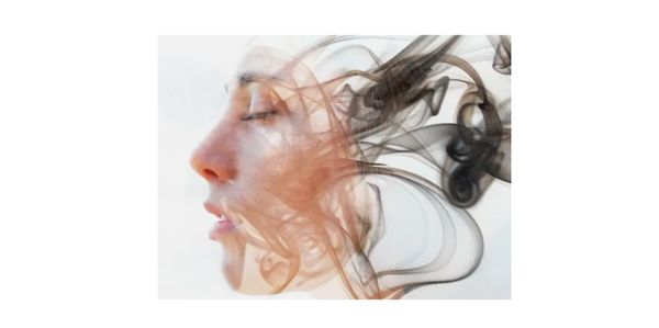 Female face profile, eyes closed in a meditative  state with swirling smoke around head & face.