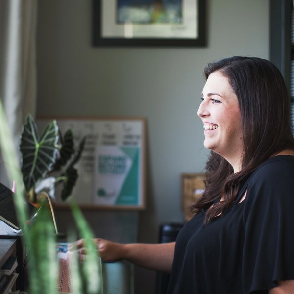 Libby Cole, Enneagram Coach, smiling at her computer while offering leadership coaching & mediation.