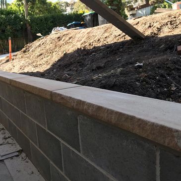 Block retaining wall with sandstone caping