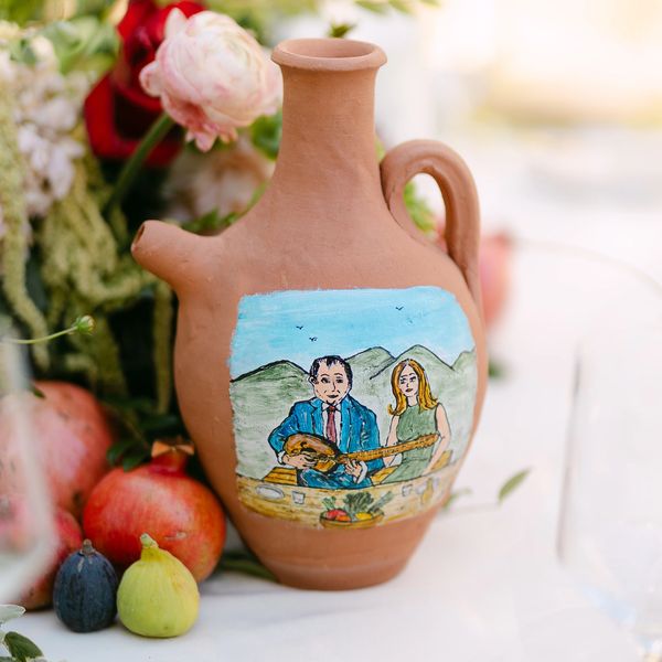 Decorative clay jug with painting surrounded by fruits and flowers for Middle Eastern wedding at Hummingbird Nest Ranch in Santa Susana.