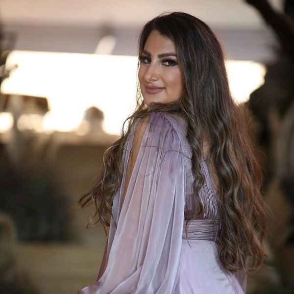 Woman smiling with long hair and purple dress