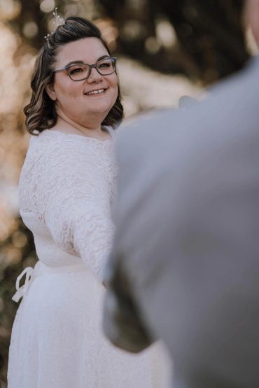 Smiling woman wearing glasses with hair accessory.