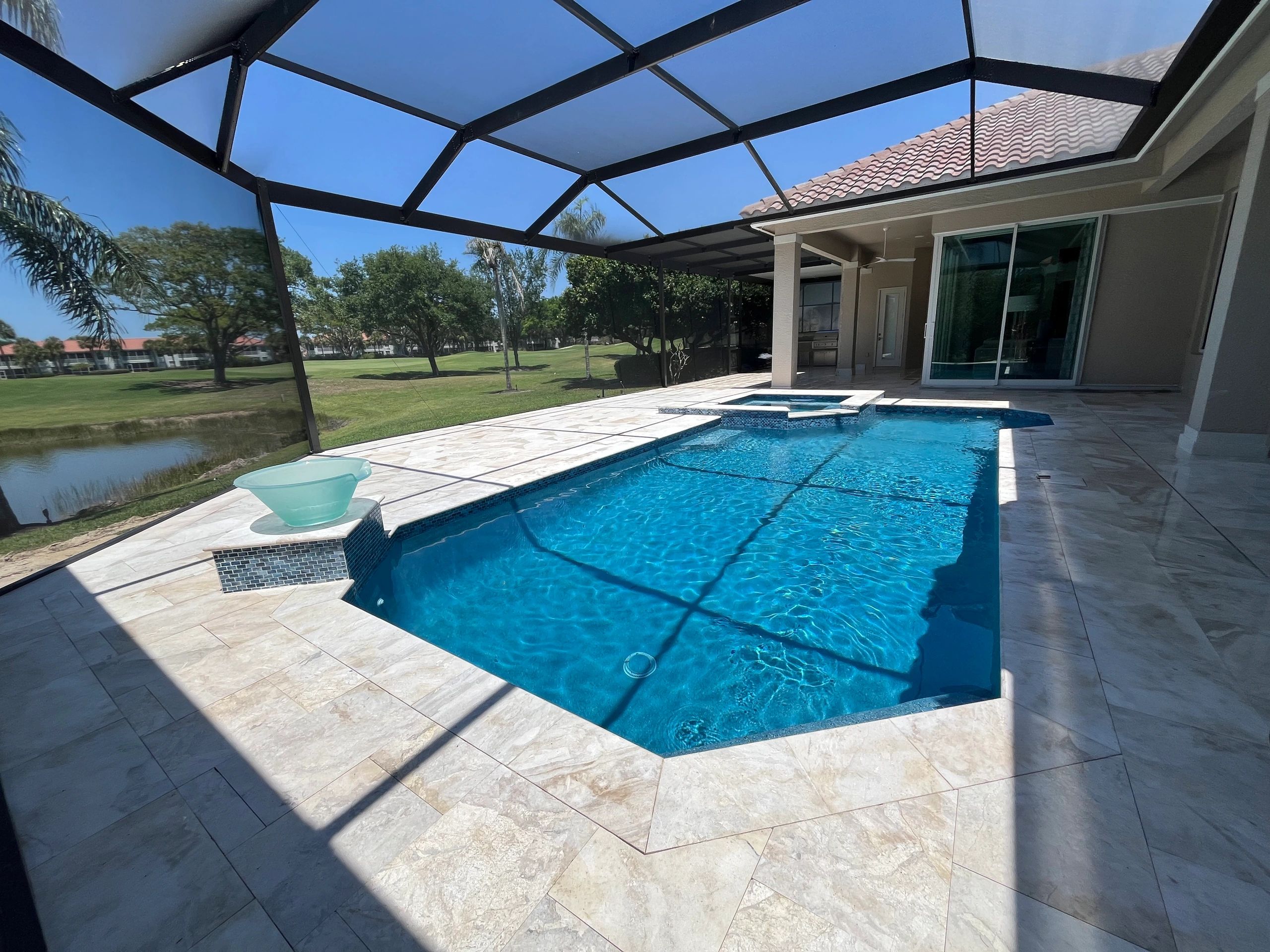 Modern backyard pool with clear blue water under a screened enclosure.