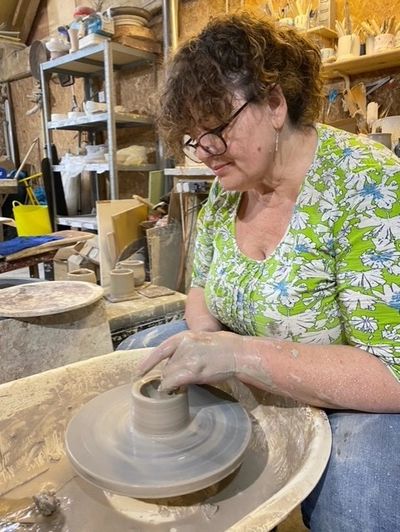 Ms AS in her pottery studio throwing a pot