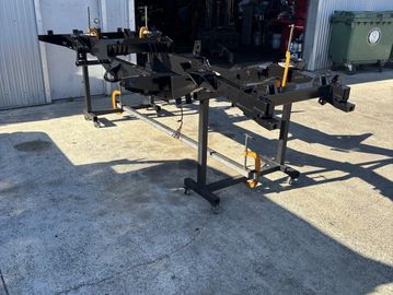 Metal frame or chassis stands outside a workshop.