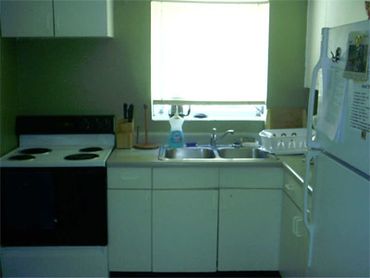 Green kitchen white cabinets stove.