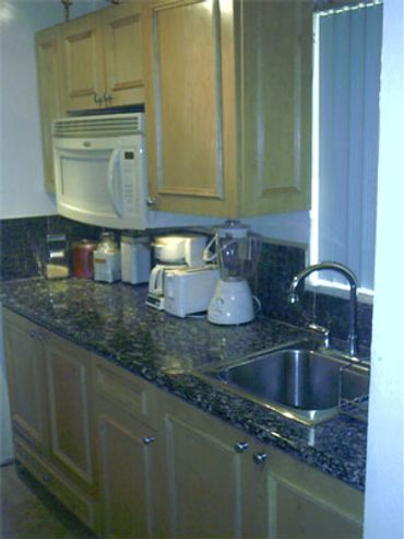 Kitchen granite counter wood cabinets.