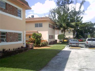 Apartment exterior driveway grassy yard.