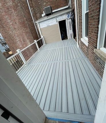 Elevated backyard deck with white railings and composite boards for low upkeep.