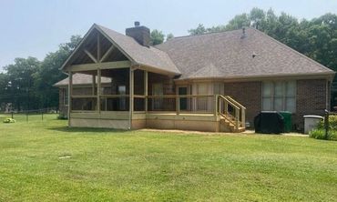 Covered porch with starburst gable design and side porch addition built for durability.