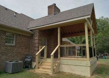 Covered deck addition with sturdy framing and railing for a functional outdoor space.
