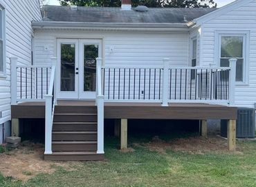 Raised backyard deck featuring white railing system and clean composite flooring.