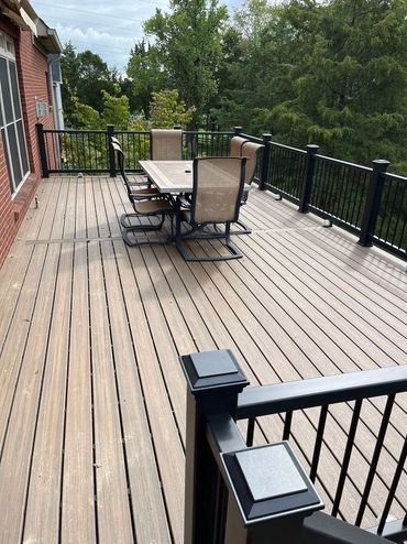 Composite backyard deck with white railings and clean boards for low-maintenance use.