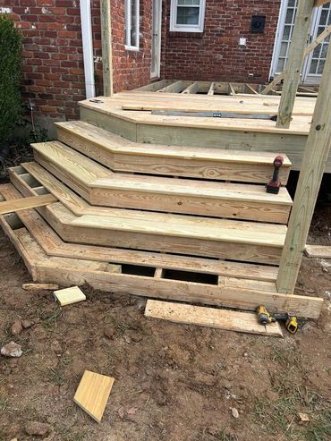 Wood deck steps with wide treads and solid framing designed for steady backyard access.