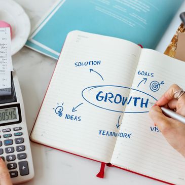 Notebook with a mind map on growth surrounded by ideas, solution, teamwork, and goals.