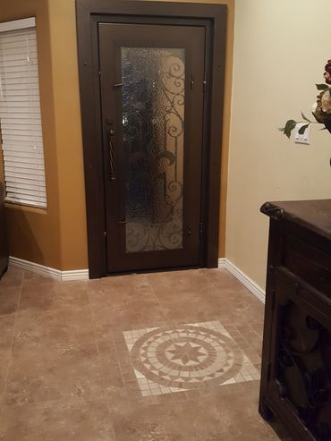Decorative glass door with intricate design and tiled floor pattern.