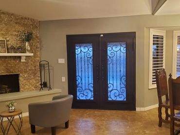 Cozy living room with a decorative glass door and stone fireplace.