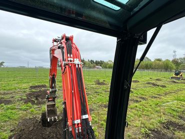 Mini excavator digging trellis holes for a vineyard in South Kingstown, RI.