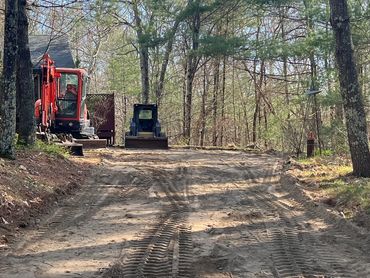 Skidsteer and mini excavator digging out old driveway in West Greenwich, RI.