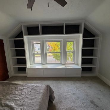Custom window wrap with bench and bookshelves and wallpaper background in shelves in Tacoma, Washing
