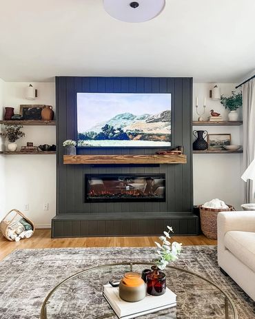 Cozy living room with a dark shiplap fireplace - media wall and floating shelves in Port Orchard, Wa