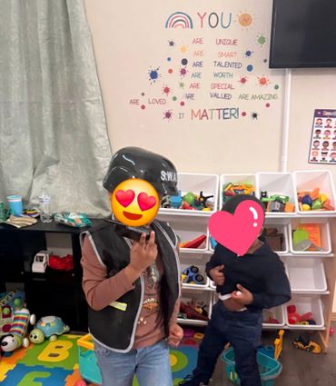 Two children playing in a colorful playroom with positive wall messages.