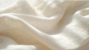 Soft, creamy fabric with gentle folds and delicate texture.