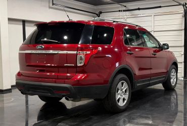 Red Ford SUV parked indoors with shiny black floor.