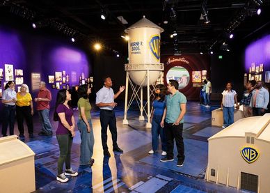 Group tour inside Warner Bros. studio exhibit.