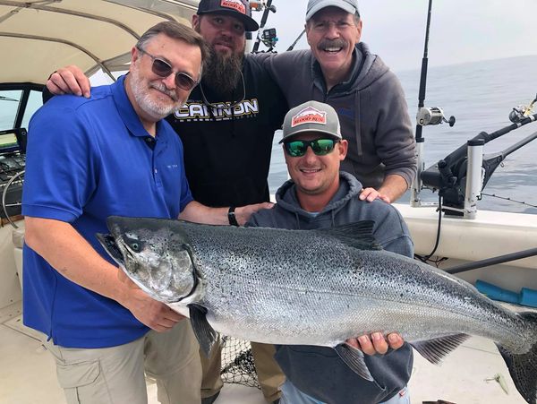 A group of people holding a large fish