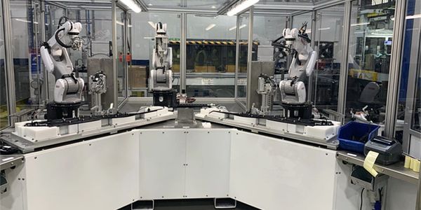 Robotic arms in an automated workspace.