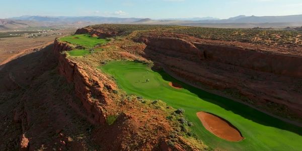 A golf course nestled in a rocky canyon with vibrant green fairways.
