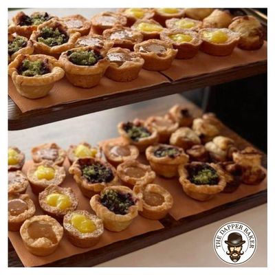 Assorted mini tarts with various fillings on display.
