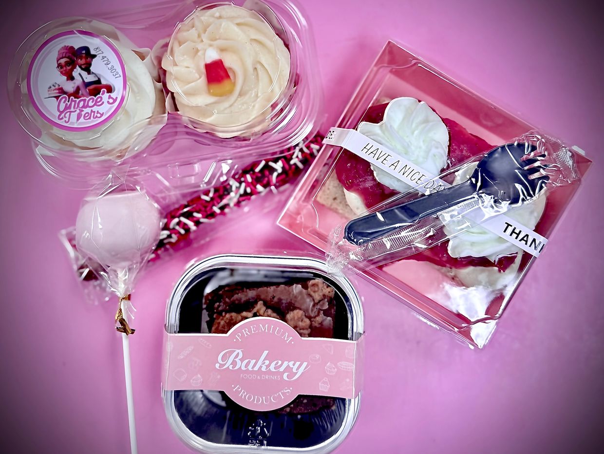 Assorted packaged bakery treats on a pink surface.