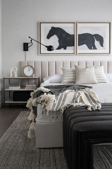 Model unit design with horse diptych, upholstered headboard, chic neutral bedding and modern sconces