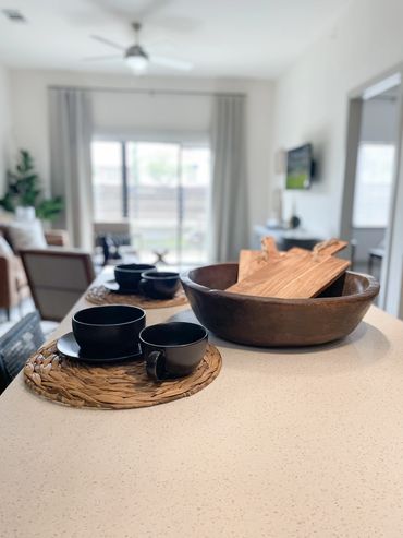 Model apartment living room with camel sofa, modern chairs, and abstract art at Axis 3700 in Texas