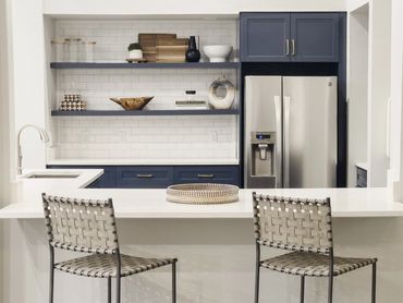 Multifamily clubroom kitchen renovation with Hale Navy cabinets, floating shelves, and subway tile
