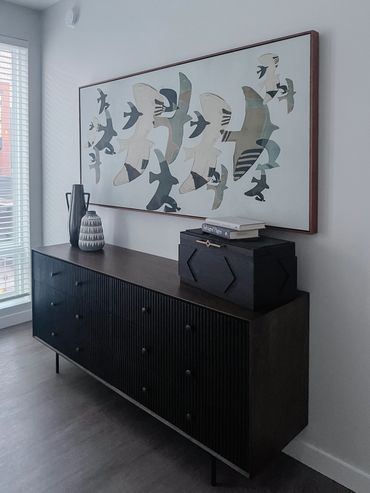 Multifamily model interior design bedroom dark finish dresser with decor and modern large artwork