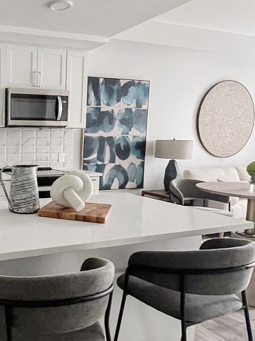 Model apartment kitchen at High Street with abstract wall art and gray counter stools
