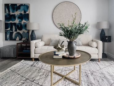 Model unit at multifamily property with curated FF&E; abstract art, soft textures, and metals