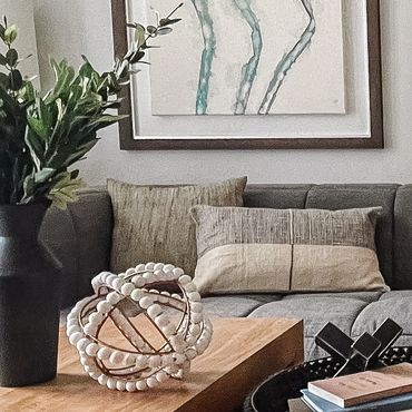 Multifamily interior model with modern gray sofa, abstract art, curated decor, and geometric rug