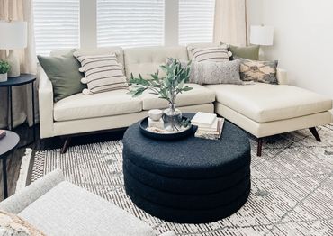 Model apartment living room with neutral furniture and wood accents – Altitude 970 Kansas City