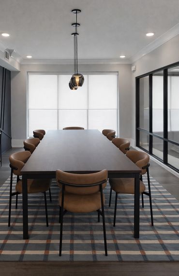 Renovated conference room at Windsor Stadium Walk with striped blue and rust area rug, upholstered d
