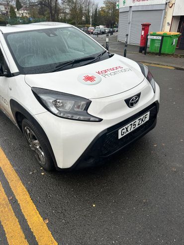 White Toyota car with Kamsons Pharmacy logo parked on Cedar Road.