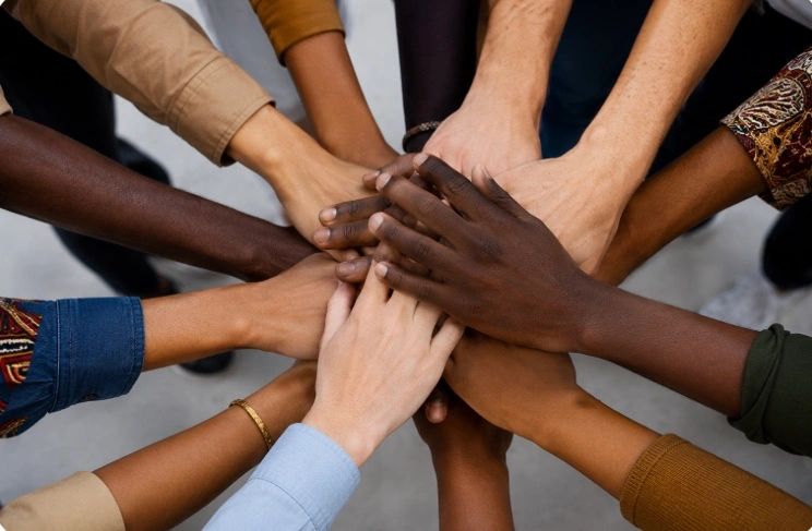 Diverse hands stacked together symbolizing unity.