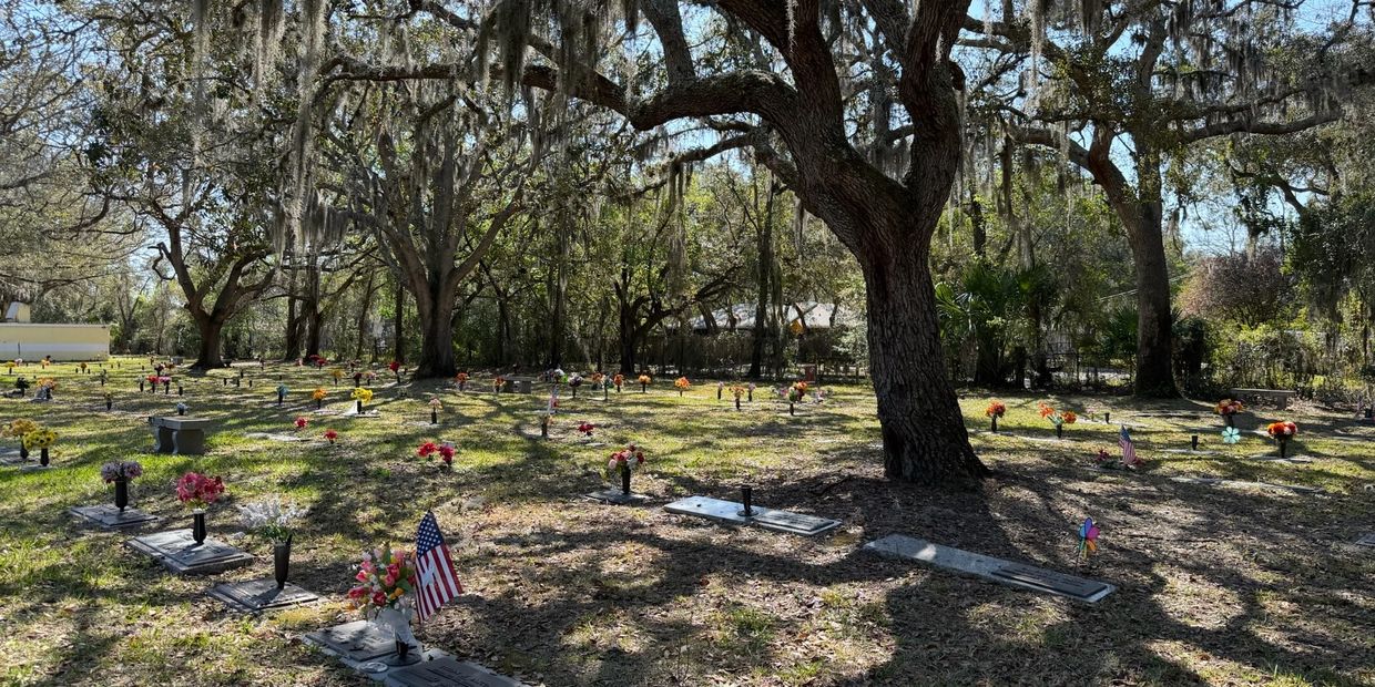 Peaceful burial grounds beneath mature live oak trees at Beaches Memorial Park