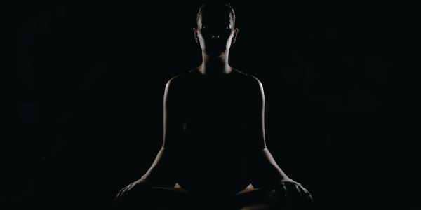 person sitting in a meditation pose connecting their mind and body