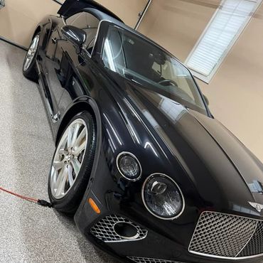 black bentley that was just detailed in a garage